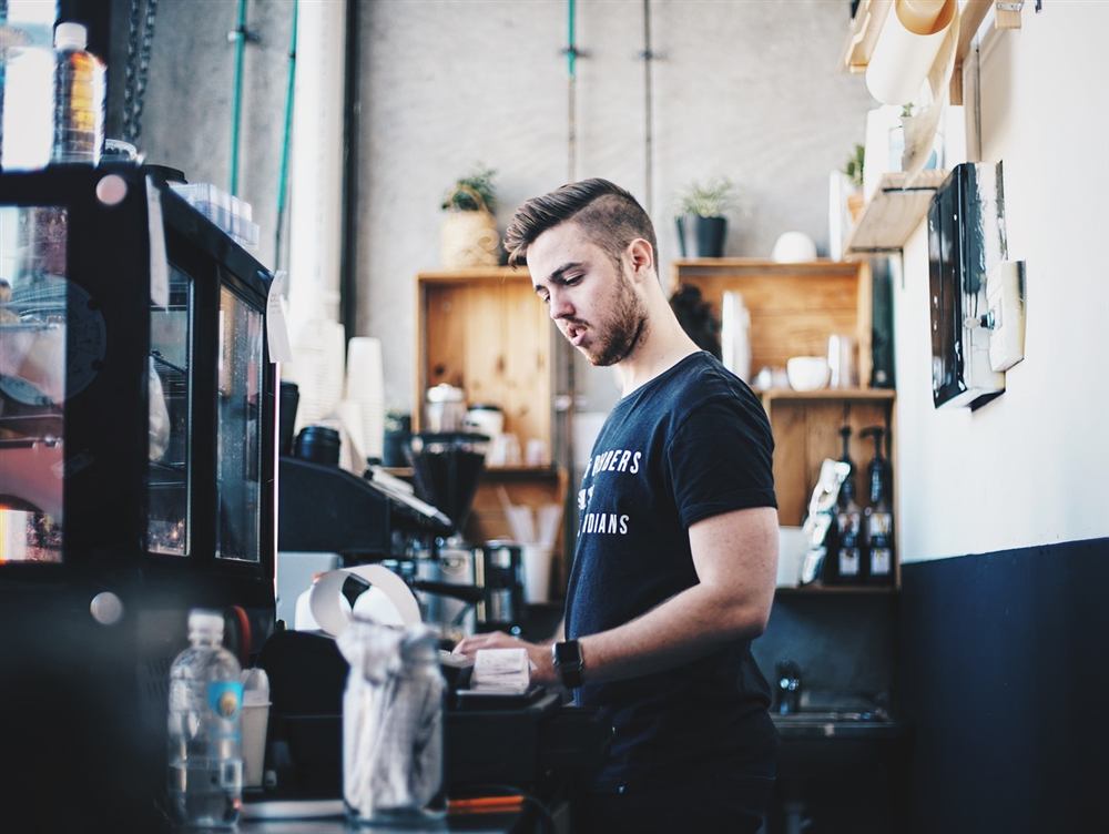 Barista przygotowuje kawę przy ekspresie